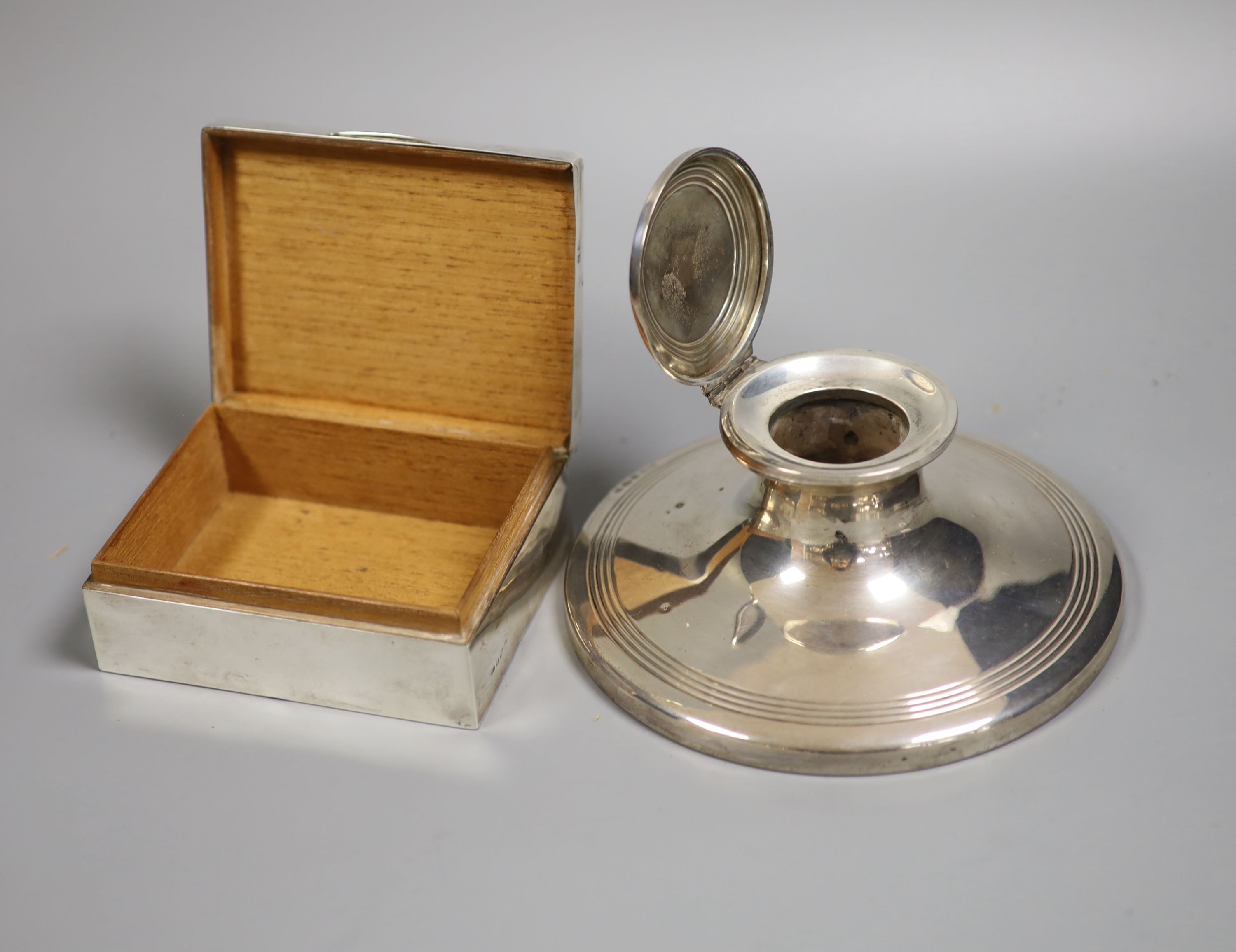 A George V silver mounted capstan inkwell, 15.2cmm weighted and a silver mounted cigarette box.